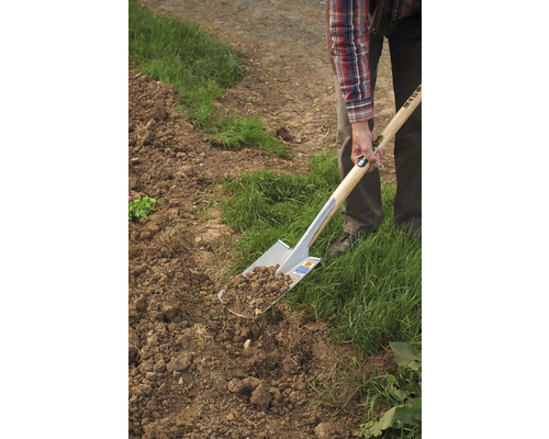 Eine Person sticht mit einem Spaten Erde um.