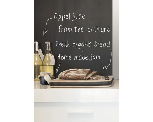 Apfelsaft, Brot und Marmelade auf einer Küchentheke vor einer Tafel