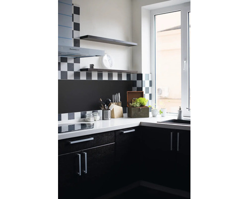 Küchenecke mit Spüle, Arbeitsplatte, Küchenutensilien und Hängeregalen.