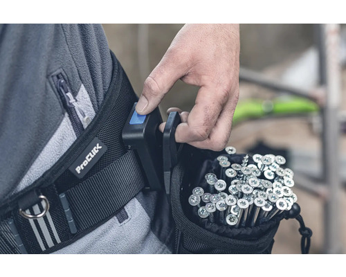 Handwerker befestigt eine ProClick Werkzeugtasche am Gürtel, gefüllt mit Schrauben.