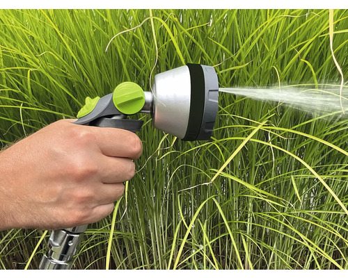 Hand hält Spritzpistole zum Bewässern von Pflanzen