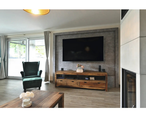 Wohnzimmer mit Fernseher, Holzschrank, Sessel und Tisch