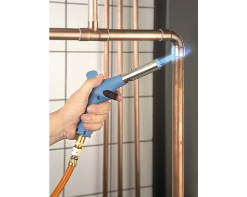 Ein Handwerker lötet Kupferrohre mit einem Lötgerät.