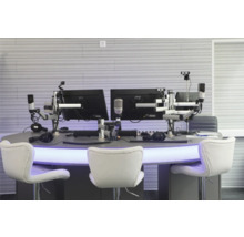 Radiostudio mit Monitoren, Mikrofonen, Kopfhörern und weißen Stühlen
