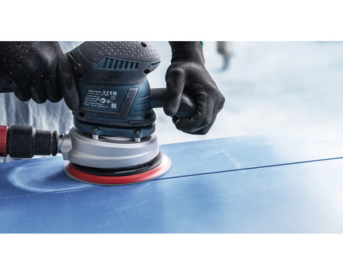Einhand-Exzenterschleifer im Einsatz auf einer blauen Oberfläche