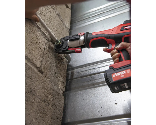 Eine Presszange wird zum Verpressen einer Rohrverbindung an einer Wand verwendet.