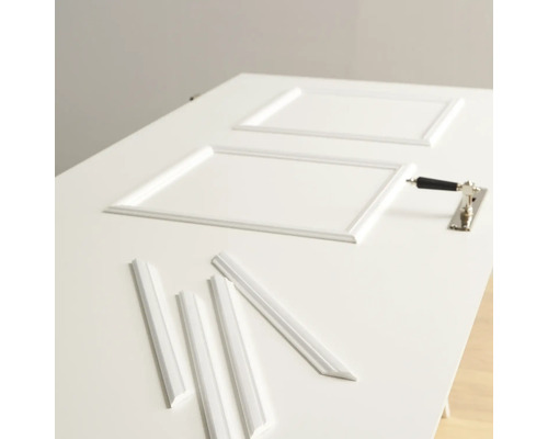 Weiße Tür mit Zierleisten und Türbeschlag