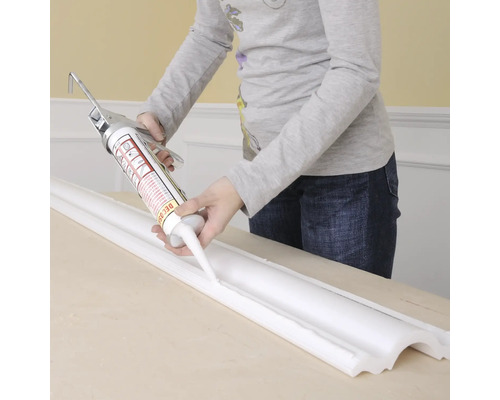 Anwendung von Dichtmasse auf einer Zierleiste mit einer Kartuschenpistole.