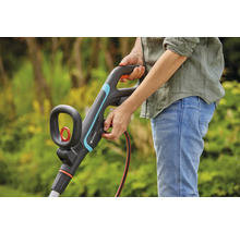 Person bedient Gardena Rasentrimmer im Garten