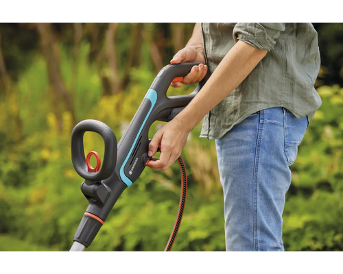 Person bedient Gardena Rasentrimmer im Garten