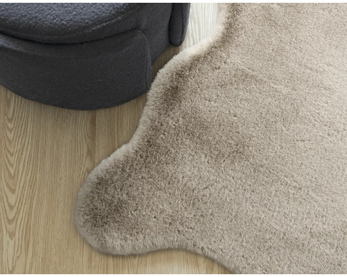 Detailansicht eines Teppichs und eines Sitzmöbels auf Holzboden