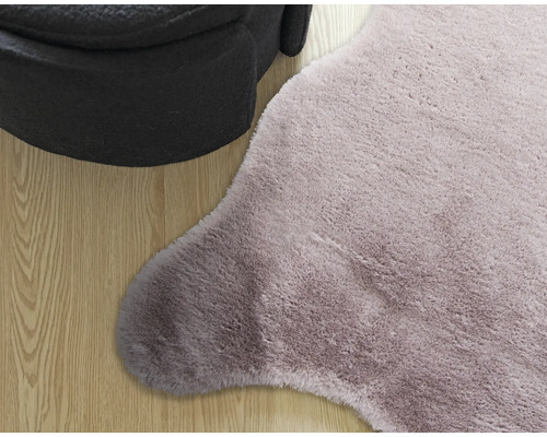 Detailaufnahme eines Teppichs mit hohem Flor und eines Hockers