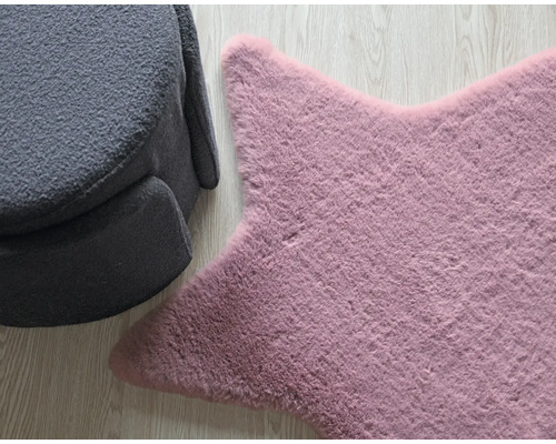 Sternförmiger Teppich neben grauem Sessel auf Holzboden