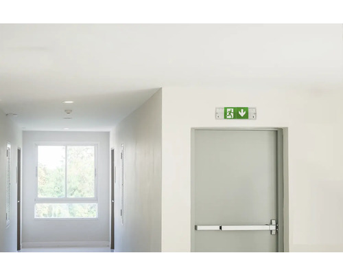 Flur mit Notausgangsschild und Tür mit Panikstange