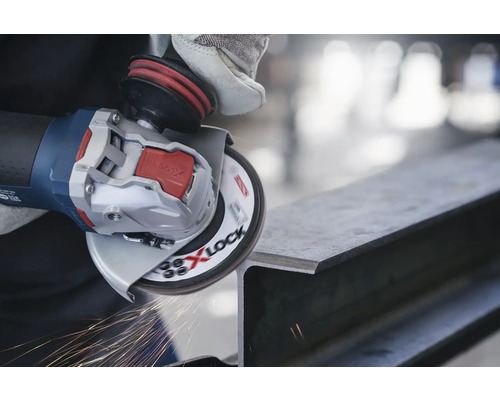 Eine Person schleift mit einem Winkelschleifer ein Metallstück, wobei Funken entstehen.