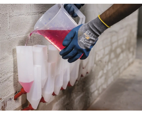 Person gießt Flüssigkeit in eine Reihe von Injektionsbehältern an der Wand.