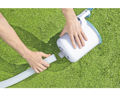 Eine Person schliesst einen Schlauch an eine Filterpumpe für einen Pool an.