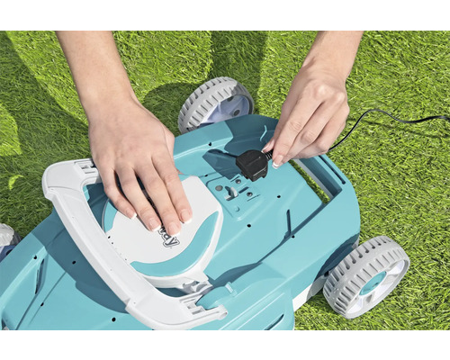 Eine Person schließt den Stecker eines Rasenmähers an.