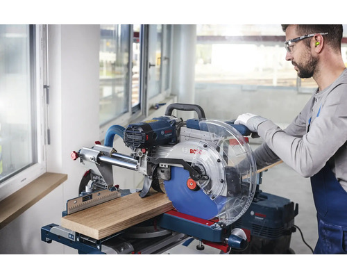Gehrungssäge beim Schneiden eines Holzstücks mit einem Handwerker