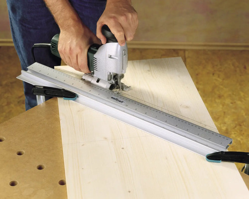 Handwerker benutzt Stichsäge mit Führungsschiene auf Holz