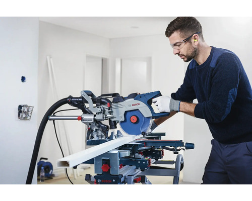 Mann mit Schutzbrille und Gehörschutz, der eine Bosch Kappsäge zum Schneiden eines Werkstücks verwendet