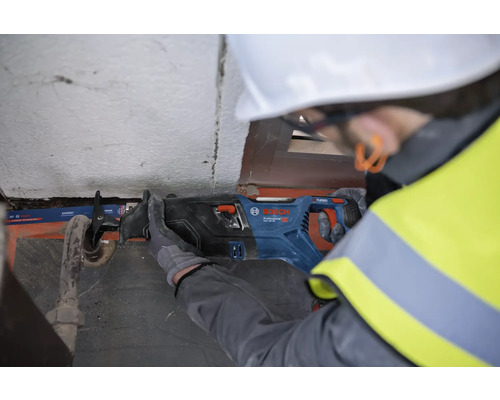 Ein Mann mit Schutzhelm sägt ein Rohr mit einer Bosch Säbelsäge.