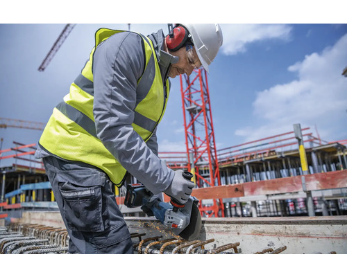 Ein Bauarbeiter benutzt einen Winkelschleifer auf einer Baustelle.