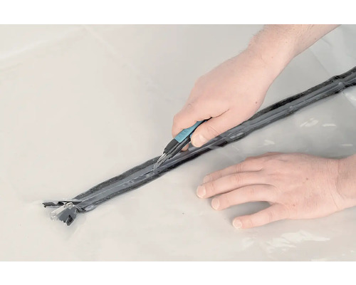 Person schneidet Dichtband mit Cuttermesser zu
