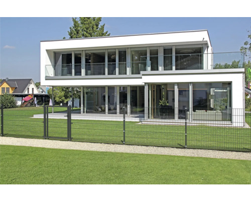 Modernes Haus mit großem Garten und Drahtzaun