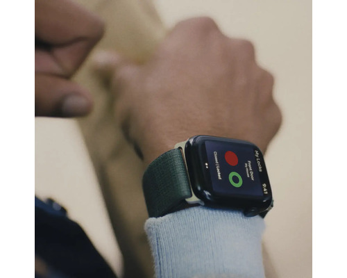 Nahaufnahme einer Smartwatch am Handgelenk, die eine App zur Steuerung von Türschlössern anzeigt.