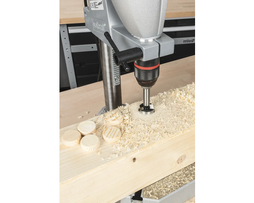 Tischbohrmaschine beim Bohren von Löchern in Holz