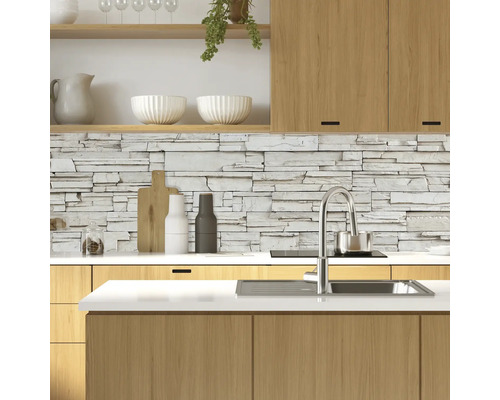 Helle Küche mit Holzschränken und einer Steinwand