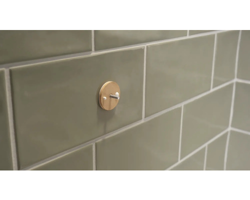 Handtuchhaken aus Holz an gefliester Wand