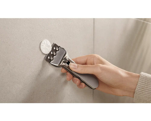 Hand mit Schaber zum Entfernen von Aufklebern