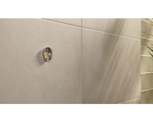 Leere Halterung für einen Seifenspender an einer Wand