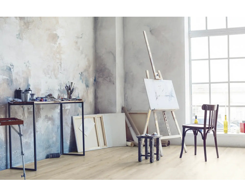 Heller Raum mit Staffelei, Tisch mit Malutensilien und Holzboden