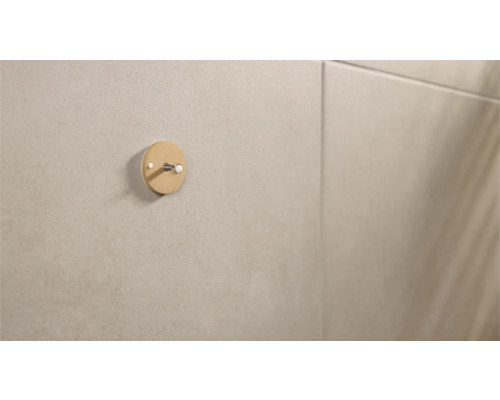 Runder Wandhaken an einer beigen Wand