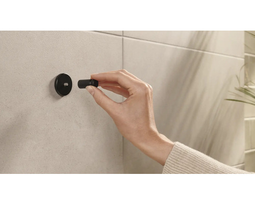 Installation einer schwarzen Bad-Garderobe an einer gefliesten Wand