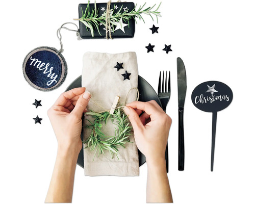 Dekorierter Weihnachtstisch mit Teller, Besteck, Geschenk und Tischdeko