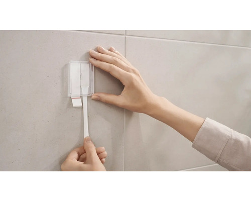 Anwendung von Klebestreifen an einer gefliesten Wand