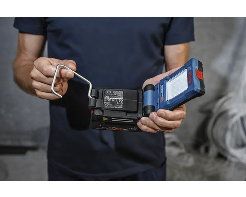 Mann hält eine Akku-Arbeitsleuchte mit Haken der Marke Bosch.