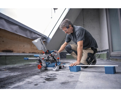 Mann benutzt eine Bosch Kapp- und Gehrungssäge zum Schneiden eines Werkstücks