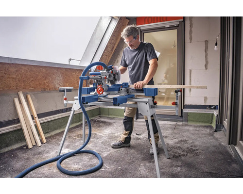 Mann arbeitet mit einer Kapp- und Gehrungssäge auf einer Baustelle