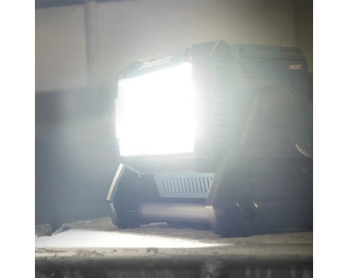 Makita Logo. Leuchtender LED-Baustrahler auf Baustelle.