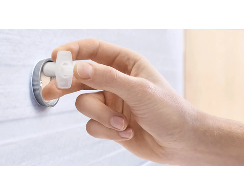 Ein Hand betätigt einen Eckregulierungsstopfen.