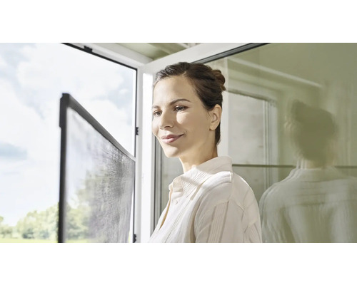 Frau am Fenster mit Insektenschutzgitter