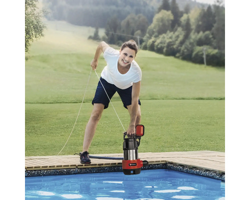 Frau senkt eine Schmutzwasserpumpe in einen Pool