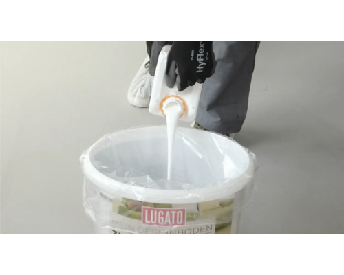 Eine Person gießt Flüssigkeit in einen Eimer Lugato Designboden