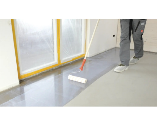 Ein Boden wird mit einer Walze versiegelt, Fenster sind mit Folie abgedeckt.