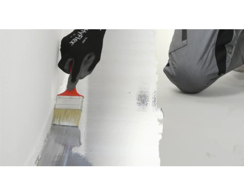 Auftragen von Flüssigkunststoff mit einem Pinsel zur Abdichtung an einer Wand